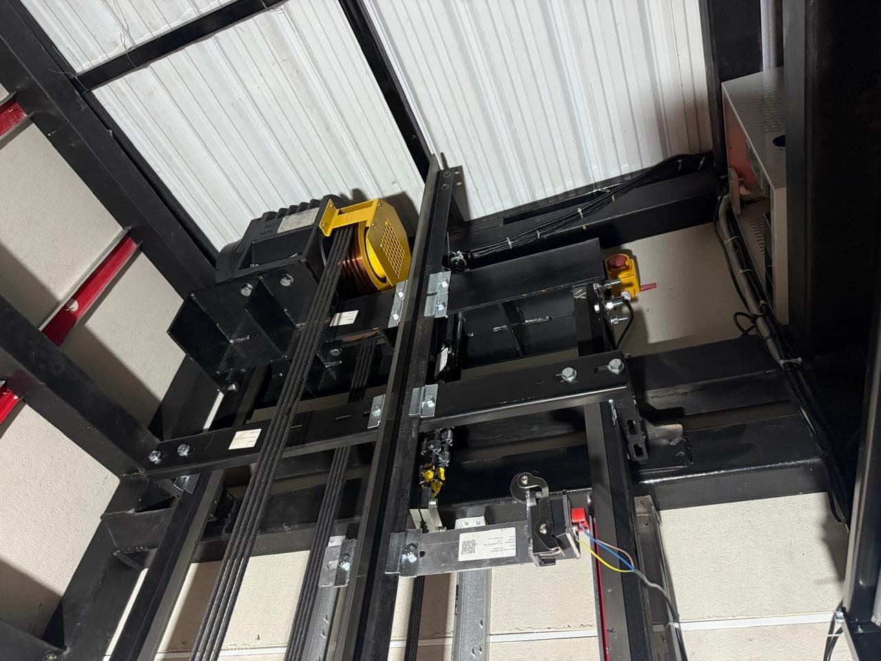 Máquina de tracción y cables instalados en la parte alta del hueco del ascensor del Aeropuerto Vanguardia de Villavicencio