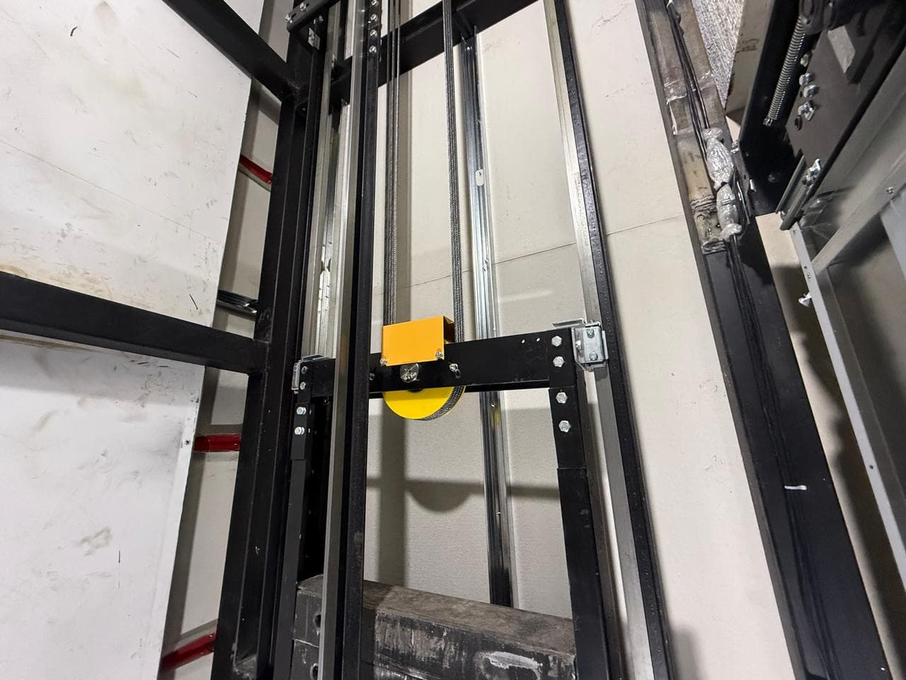 Polea deflectora y rieles guía dentro del hueco del ascensor del Aeropuerto Vanguardia