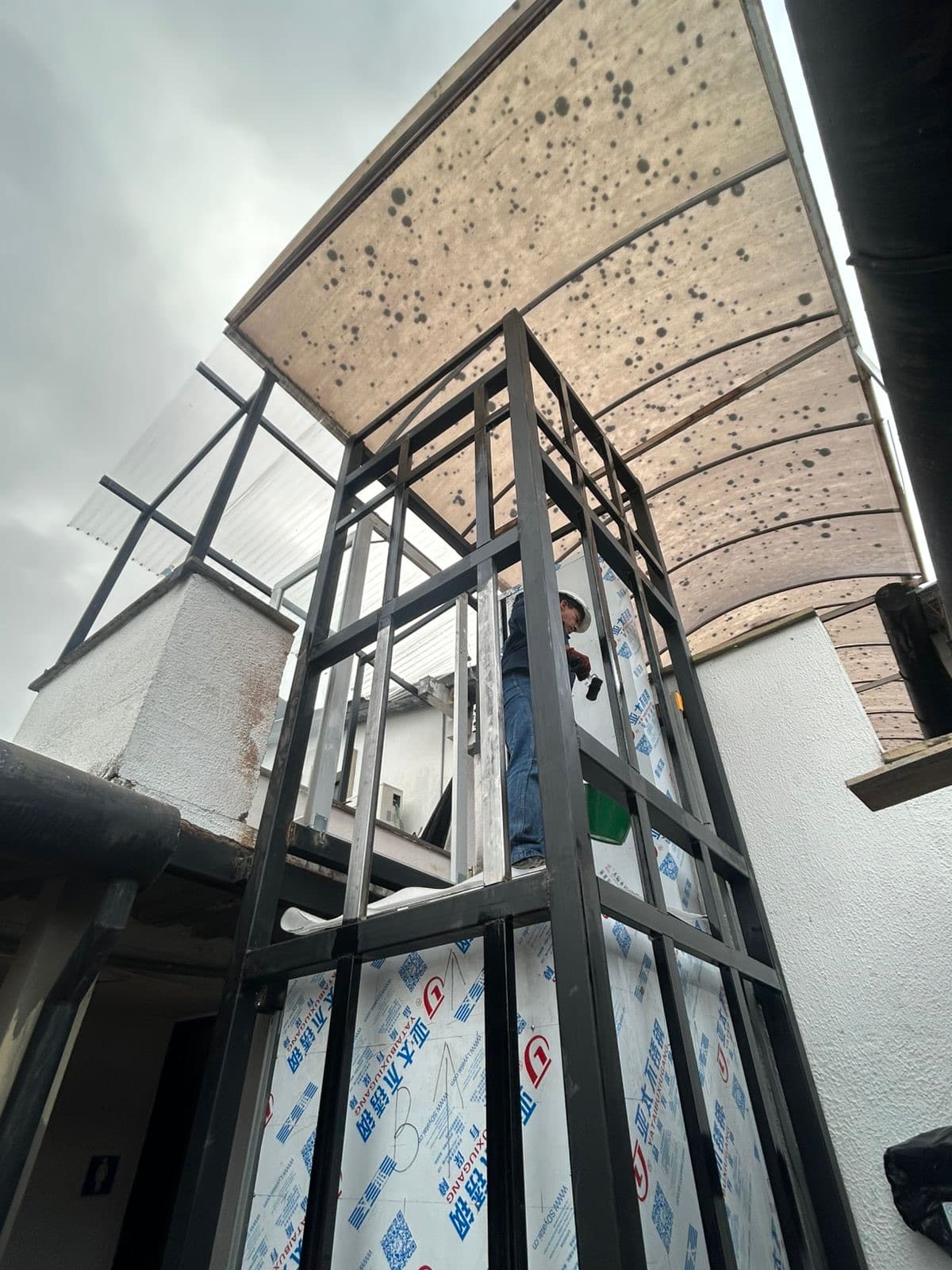 Técnico trabajando en la estructura metálica autoportante del elevador hidráulico de dos paradas en Ocaña