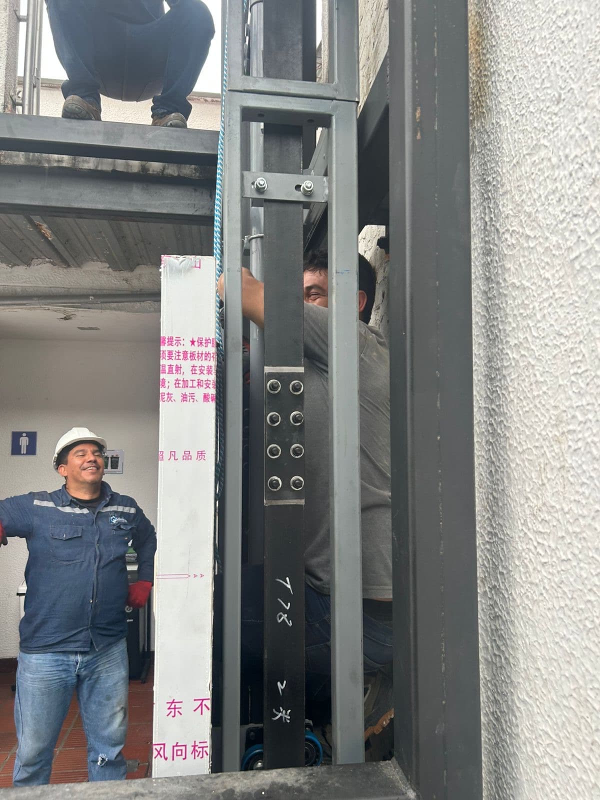 Técnicos de Quantium instalando la columna guía del elevador hidráulico en la sede de Ocaña