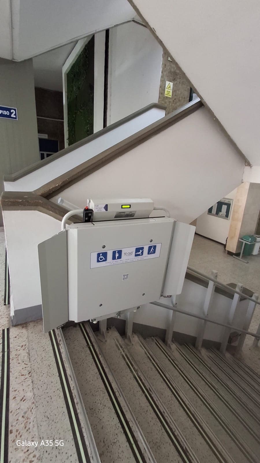 Plataforma salvaescaleras con rampas de acceso desplegadas en el descanso de la escalera del SENA de Barranquilla
