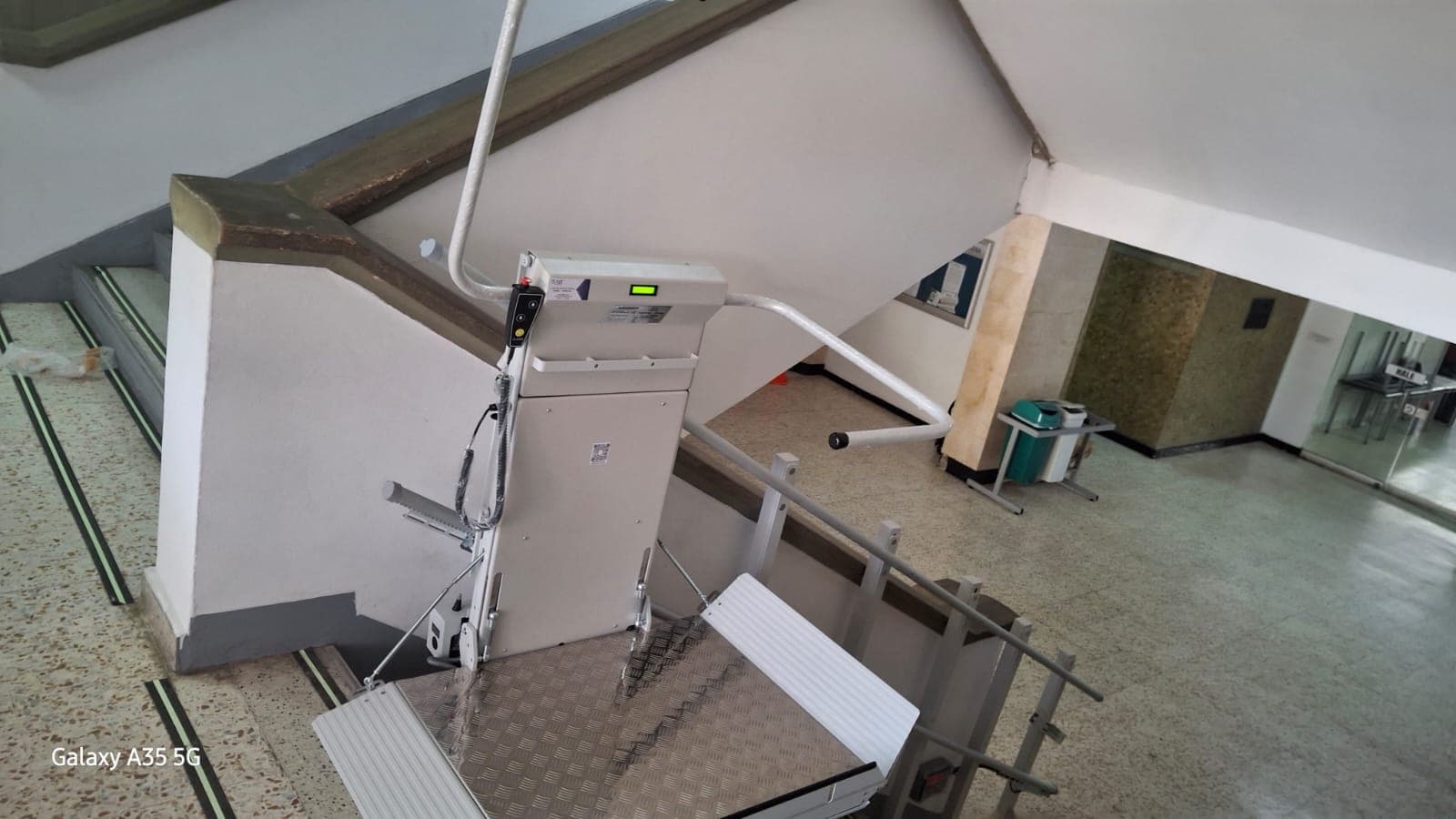 Vista superior de la plataforma salvaescaleras instalada sobre el barandal de la escalera del SENA de Barranquilla