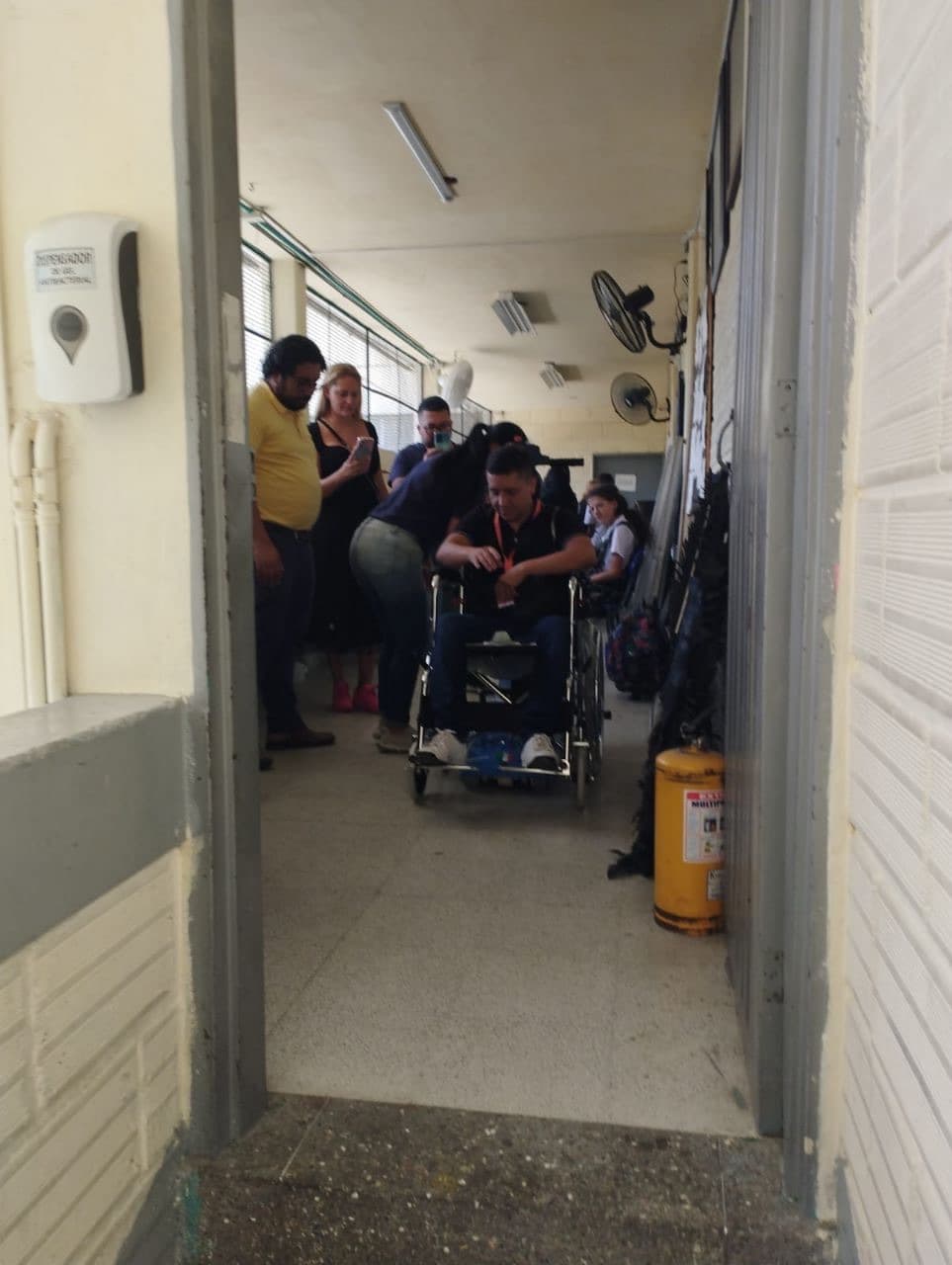 Demostración de uso de la silla salvaescalera tipo oruga con un usuario en silla de ruedas en un pasillo de la institución educativa